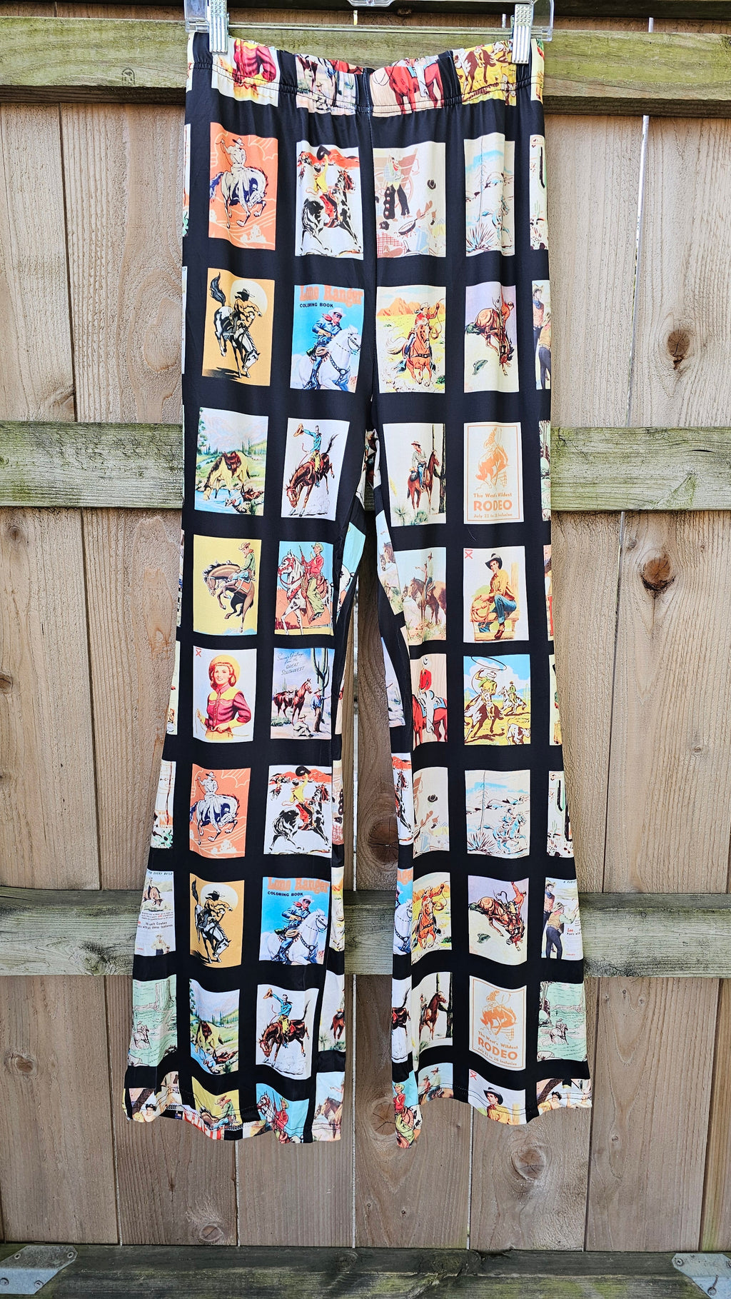 Vintage Cowboy Collage Western Flare Pants with playful rodeo and cowboy graphics against a black background.