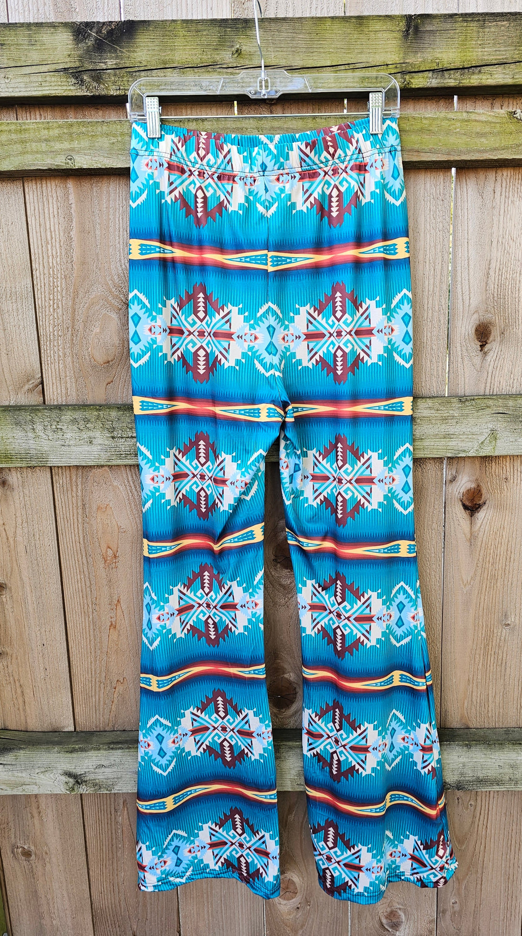 Teal Aztec flare pants featuring vibrant southwestern patterns, perfect for festival wear and modern comfort.