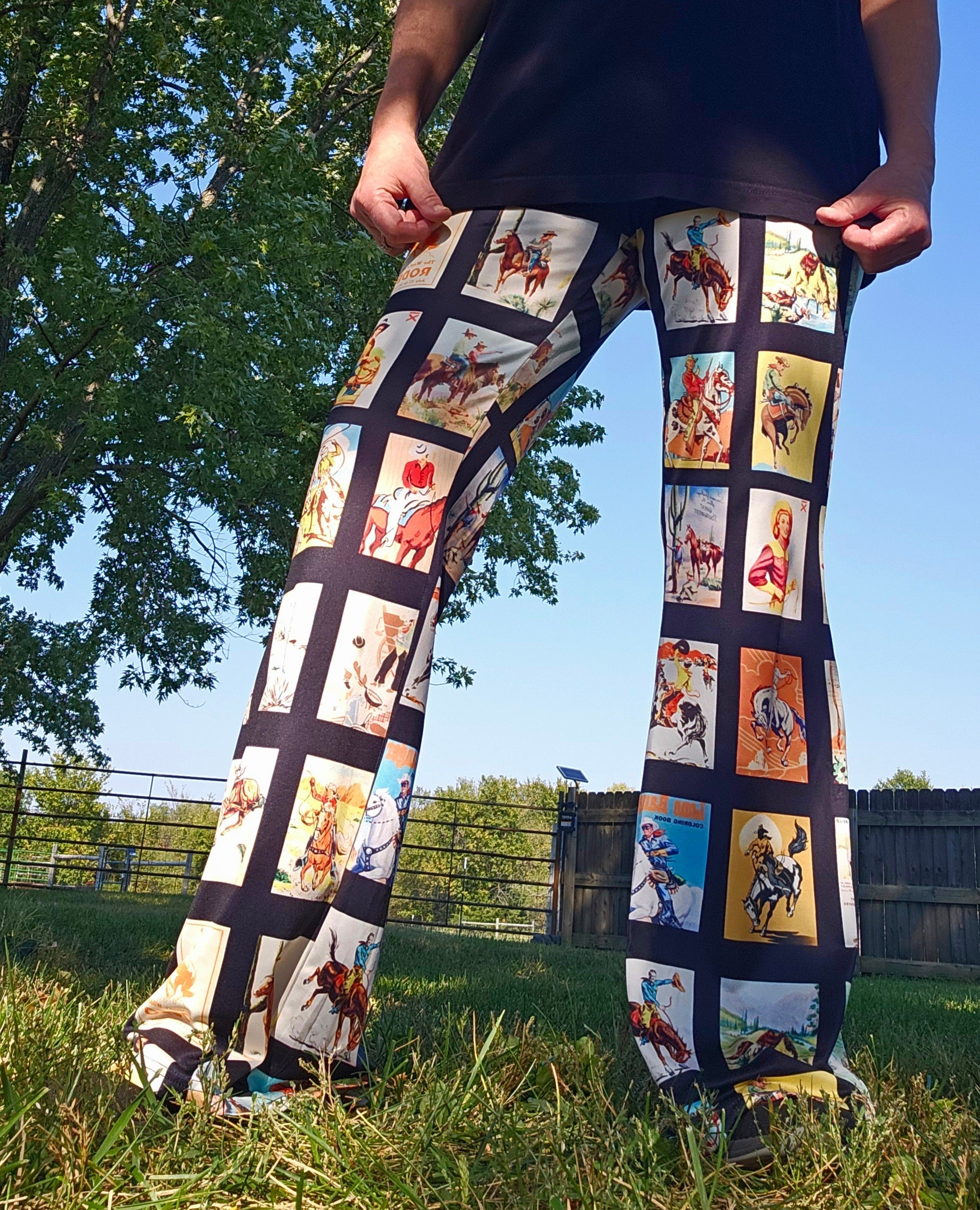 Vintage Cowboy Collage Western Flare Pants showcasing cowboy and rodeo graphics in a picturesque outdoor setting.