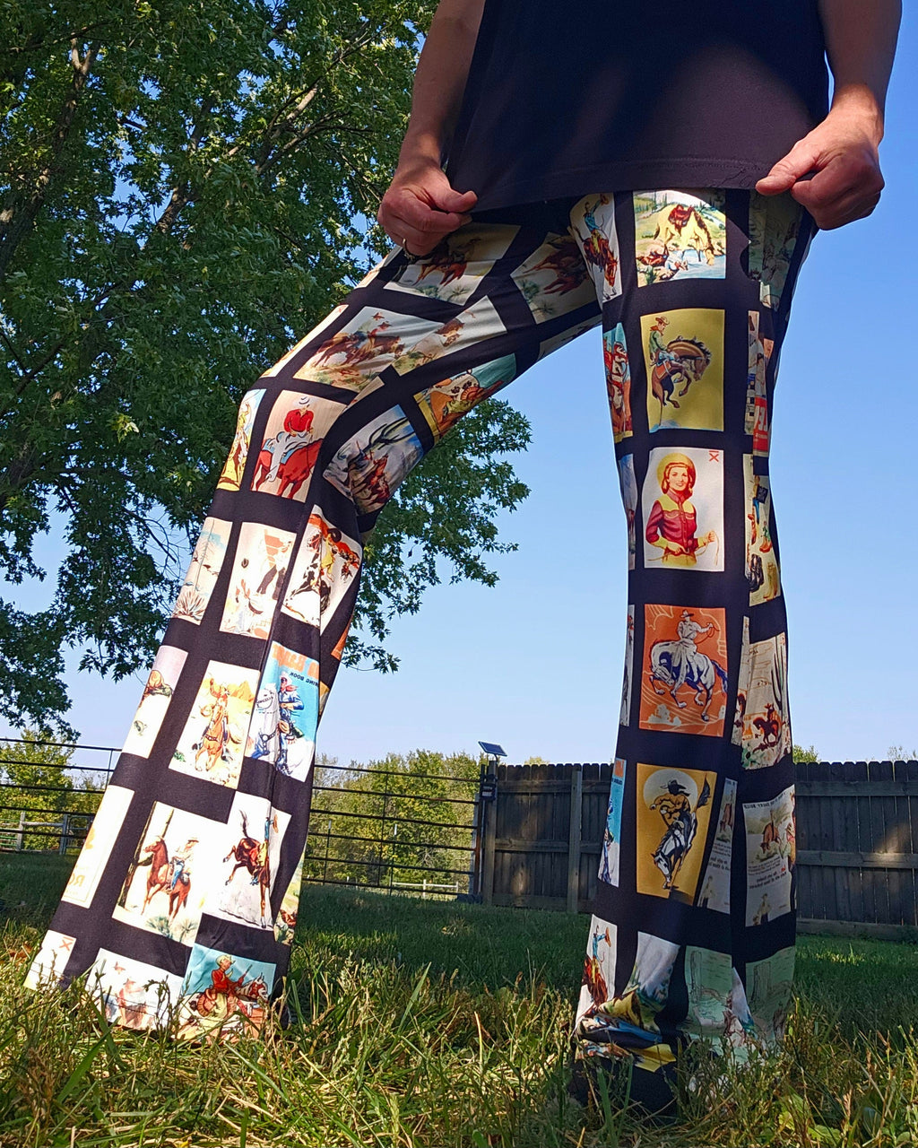Vintage Cowboy Collage Western Flare Pants featuring rodeo-themed prints in a natural outdoor setting.