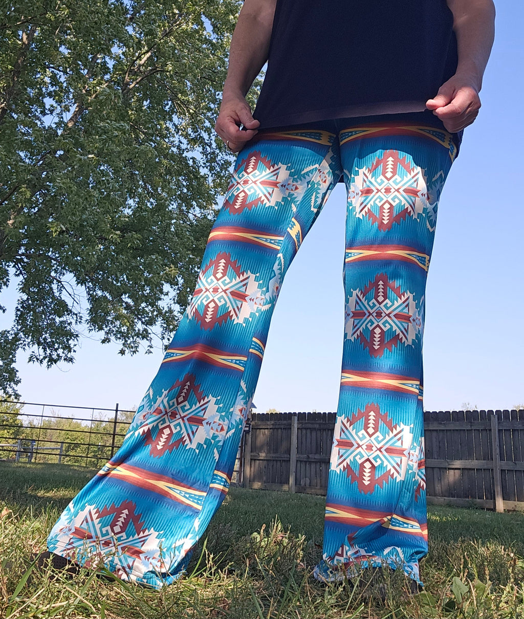 Model wearing Teal Aztec Flare Pants showcasing southwestern pattern in an outdoor setting.