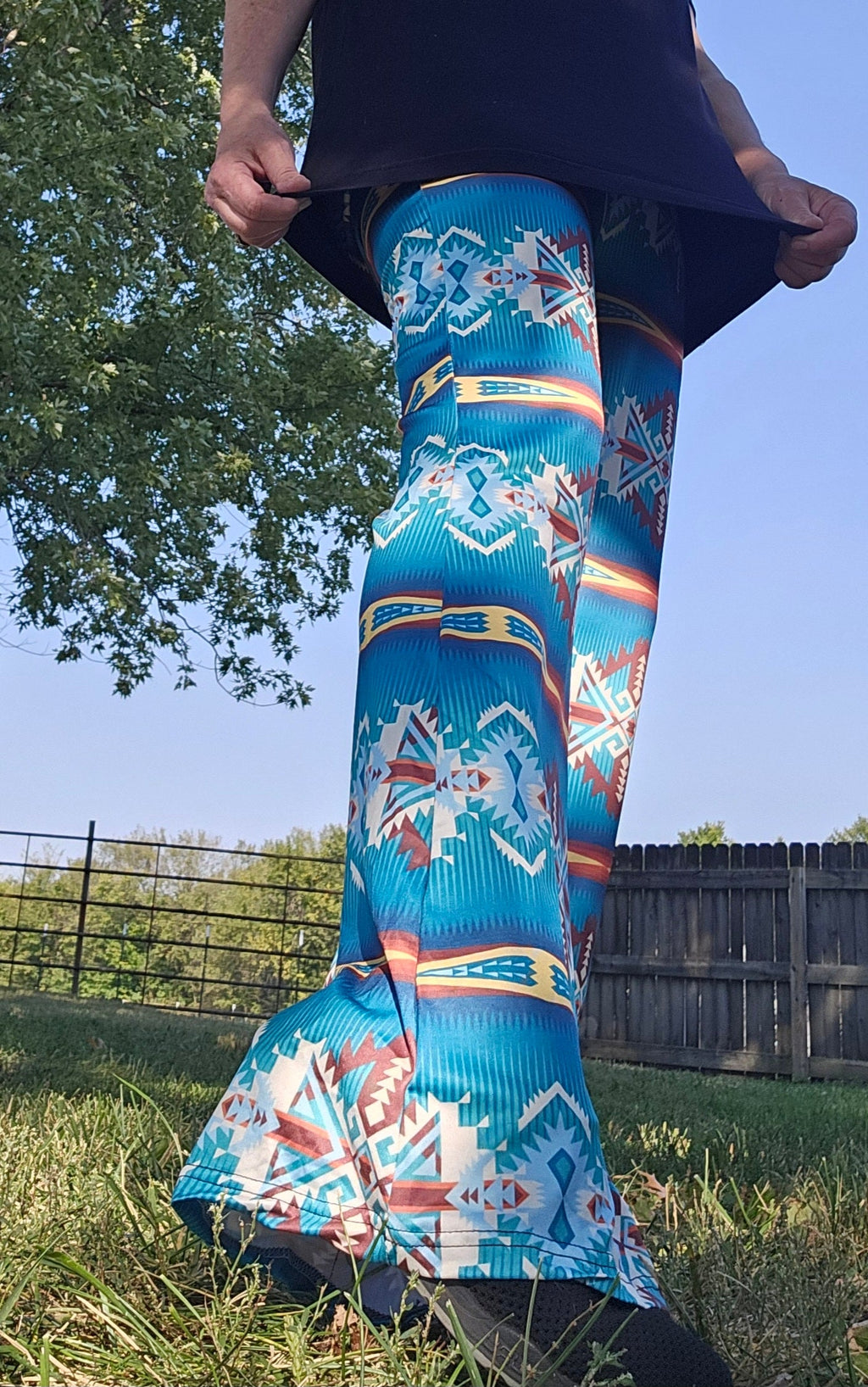 Model wearing Teal Aztec flare pants in a vibrant southwestern print, showcasing a high-waisted and flattering design.