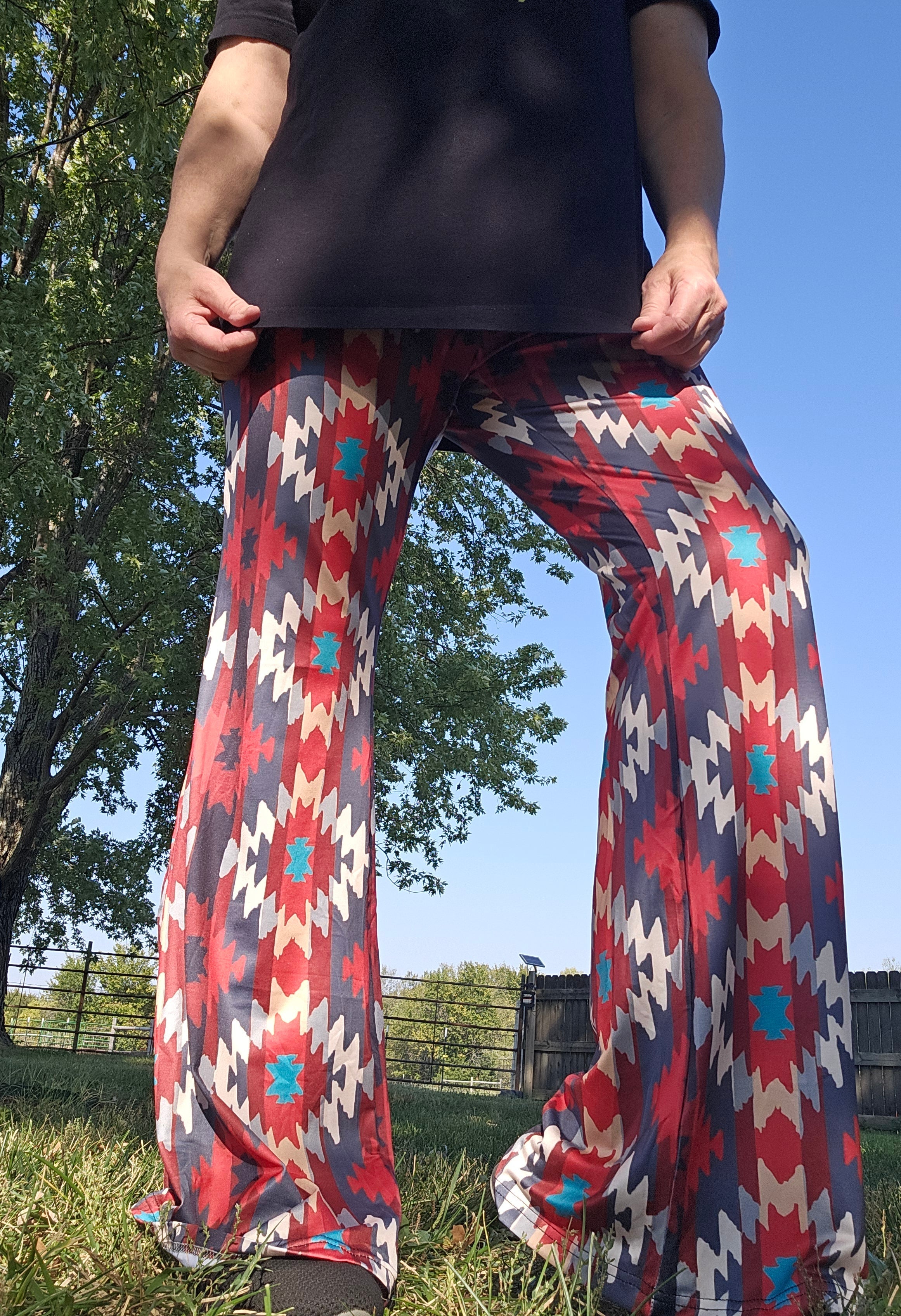Model wearing Sedona Aztec Flare Pants outdoors under a blue sky, showcasing southwestern design and vibrant colors.