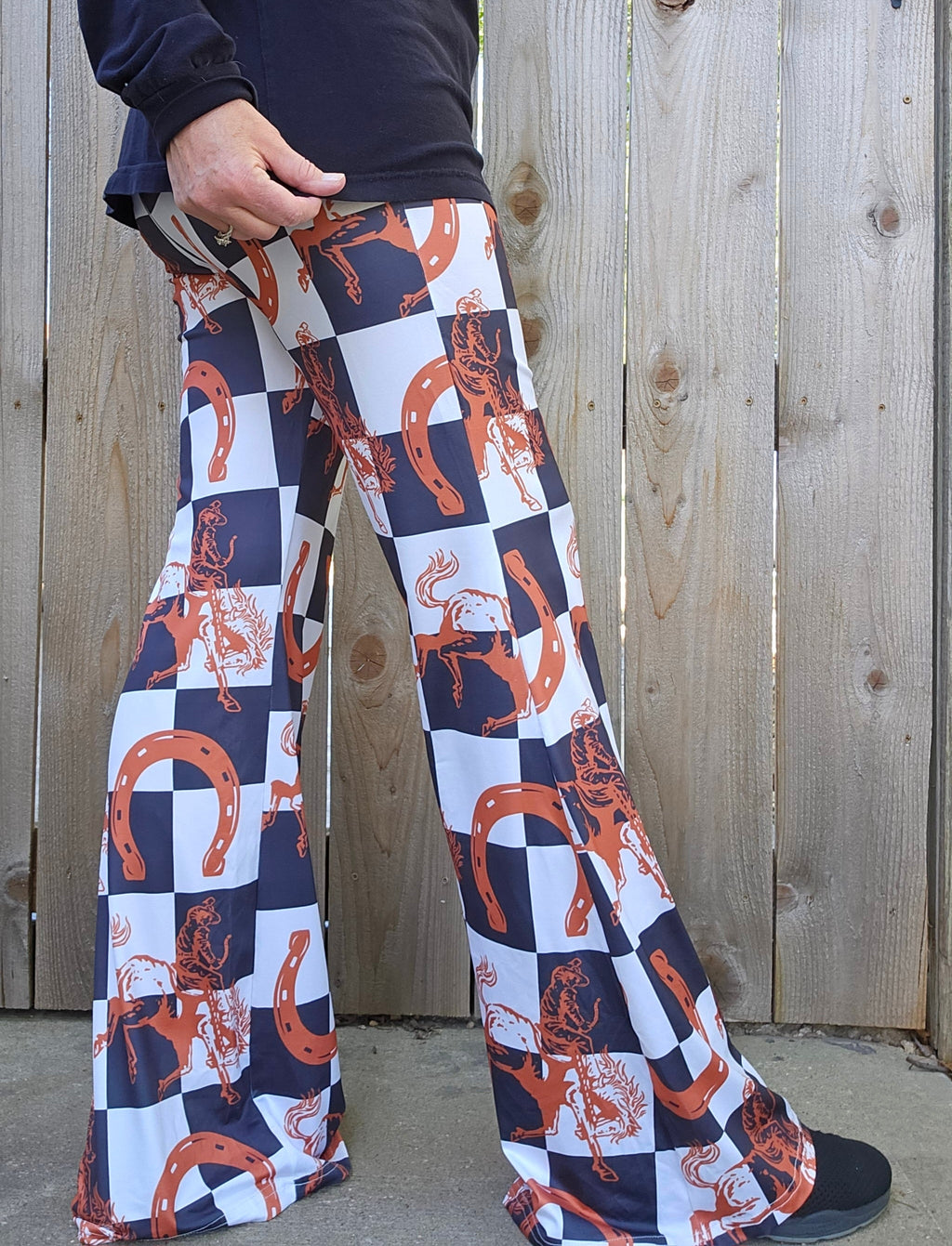 Side view of Checkered Rodeo Flare Pants showcasing Western flair with horses and horseshoes in a stylish checkered pattern.
