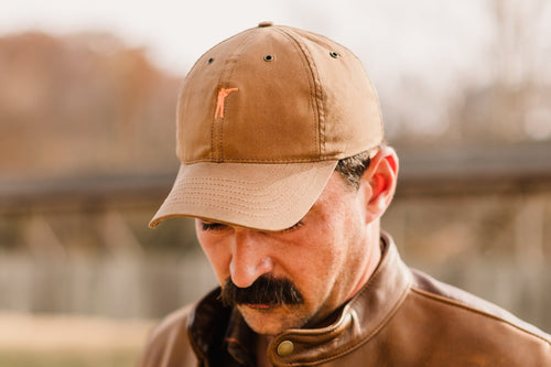 Man wearing the Arthur Field Waxed Cotton Hat, showcasing its durable and stylish design.