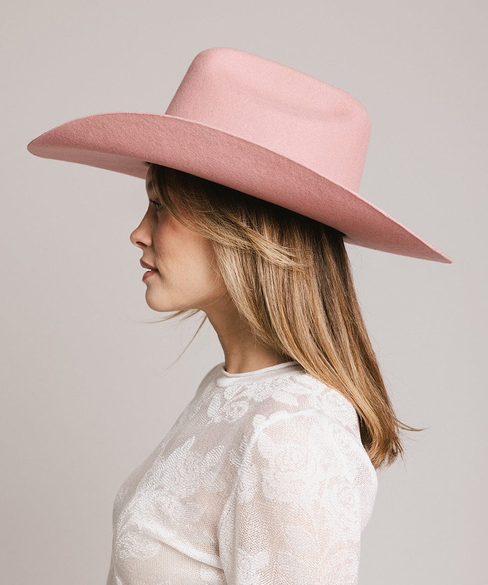 Profile view of a woman wearing a pink Teddy Cattleman cowboy hat, showcasing its classic western style.
