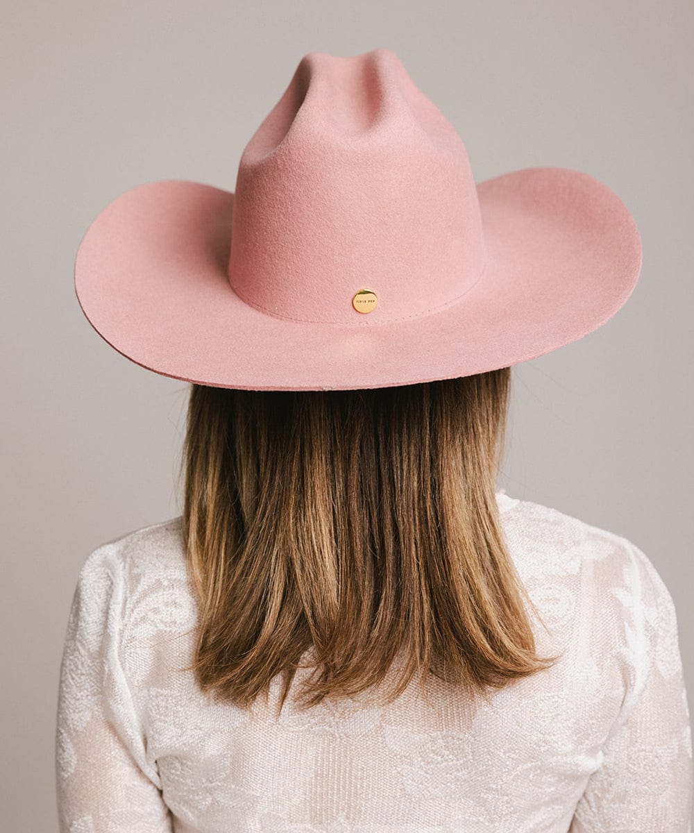 Back view of a woman wearing a pink Teddy Cattleman cowboy hat, showcasing its stylish wide brim and classic design.