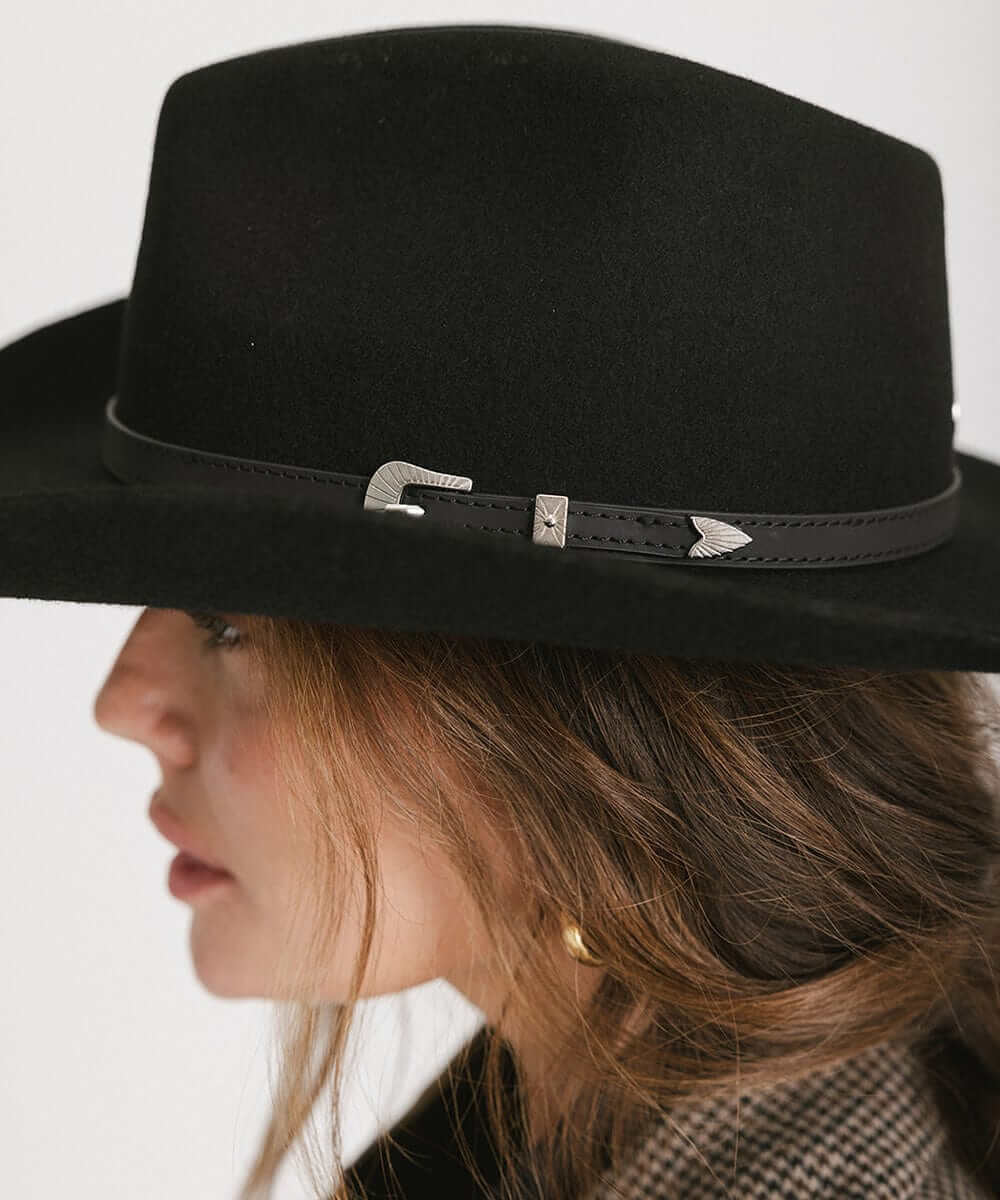 Stylish woman wearing the Dean Rancher Cowboy Hat with leather band and silver buckle detail, showcasing Western fashion.