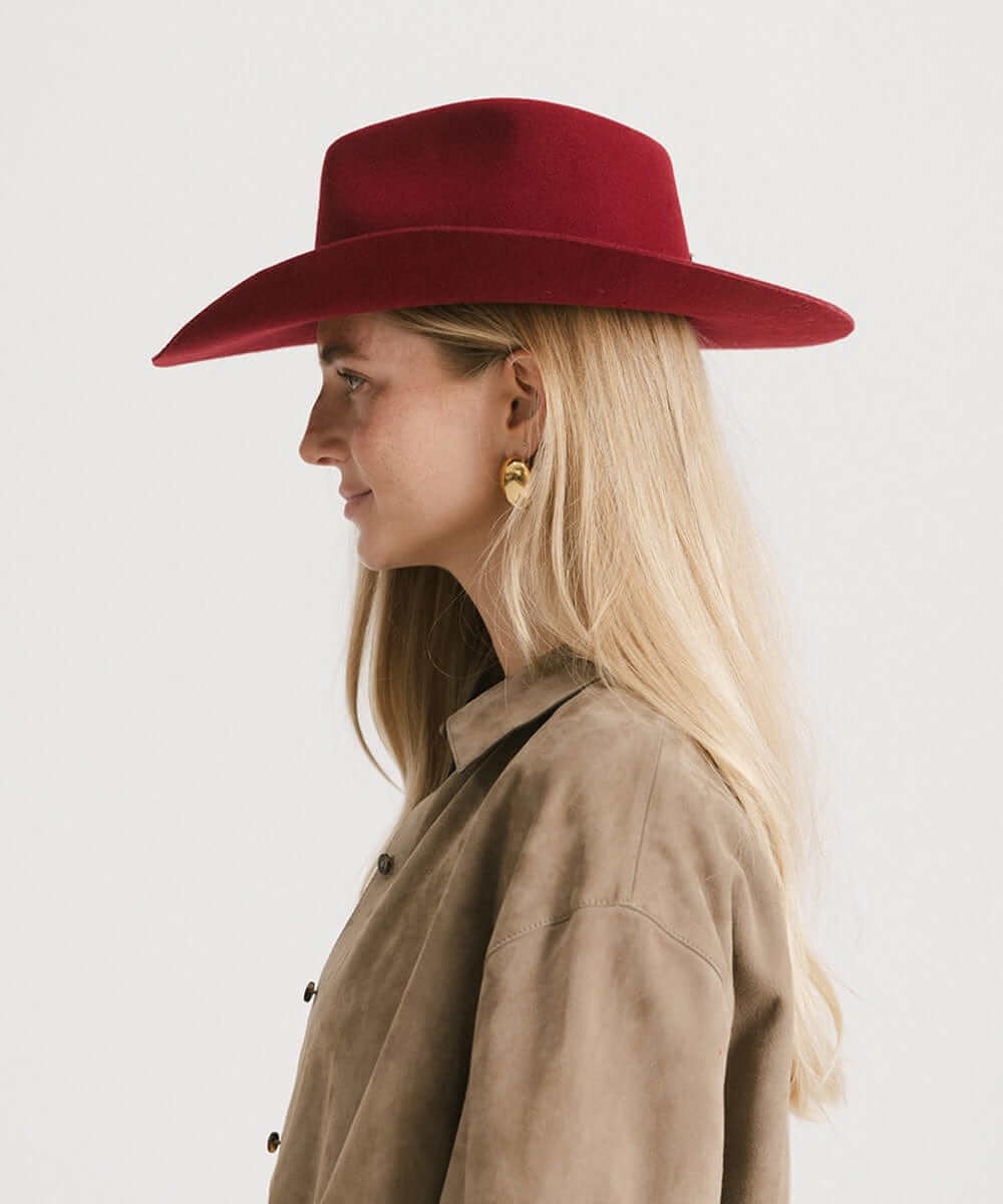 Dean Rancher Cowboy Hat showcased on a model, featuring a sculpted crown and mid-length brim in a rich burgundy hue.