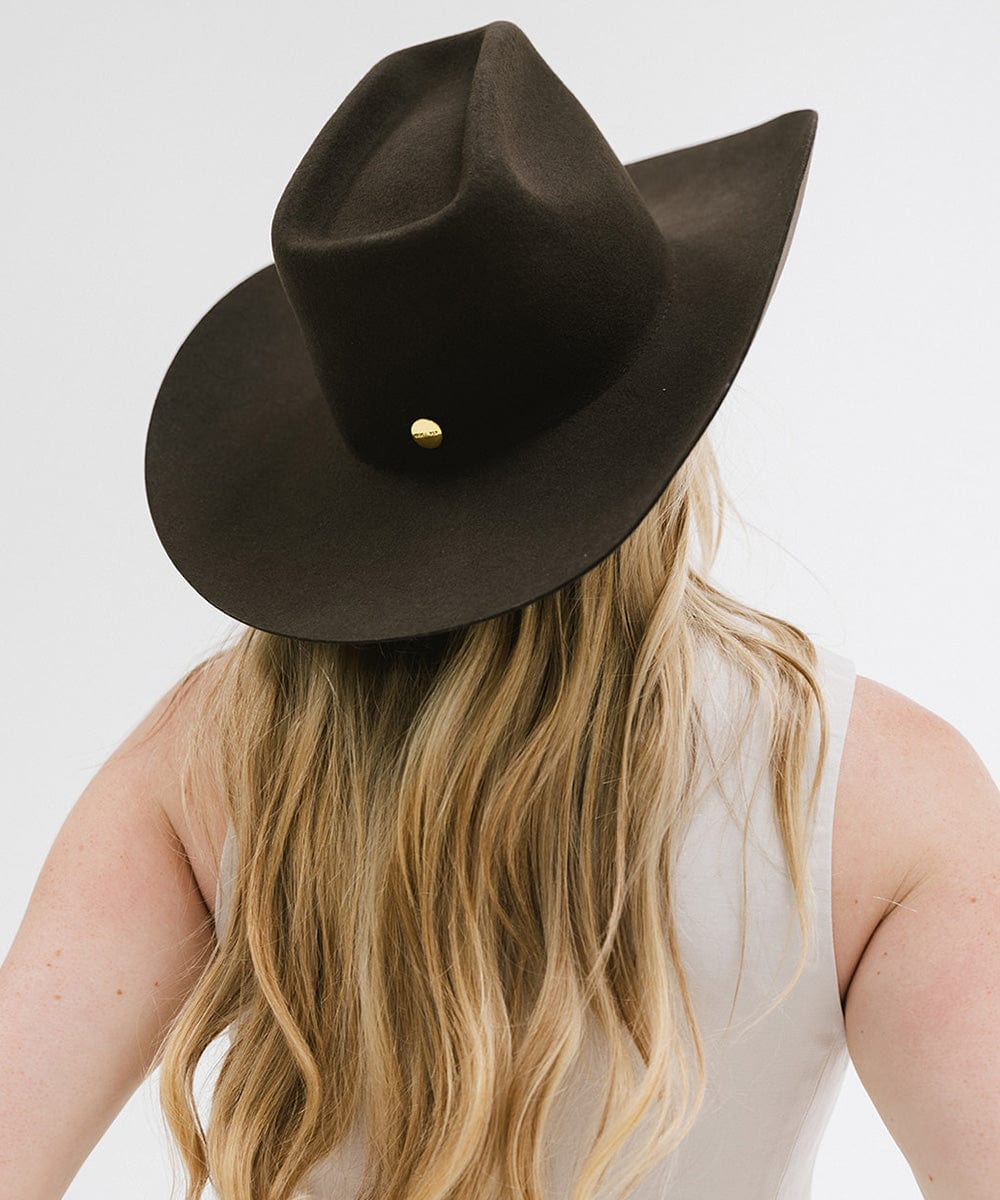 Woman wearing a stylish Lane Cowboy Hat, showcasing its unique brick top crown and wide brim design.