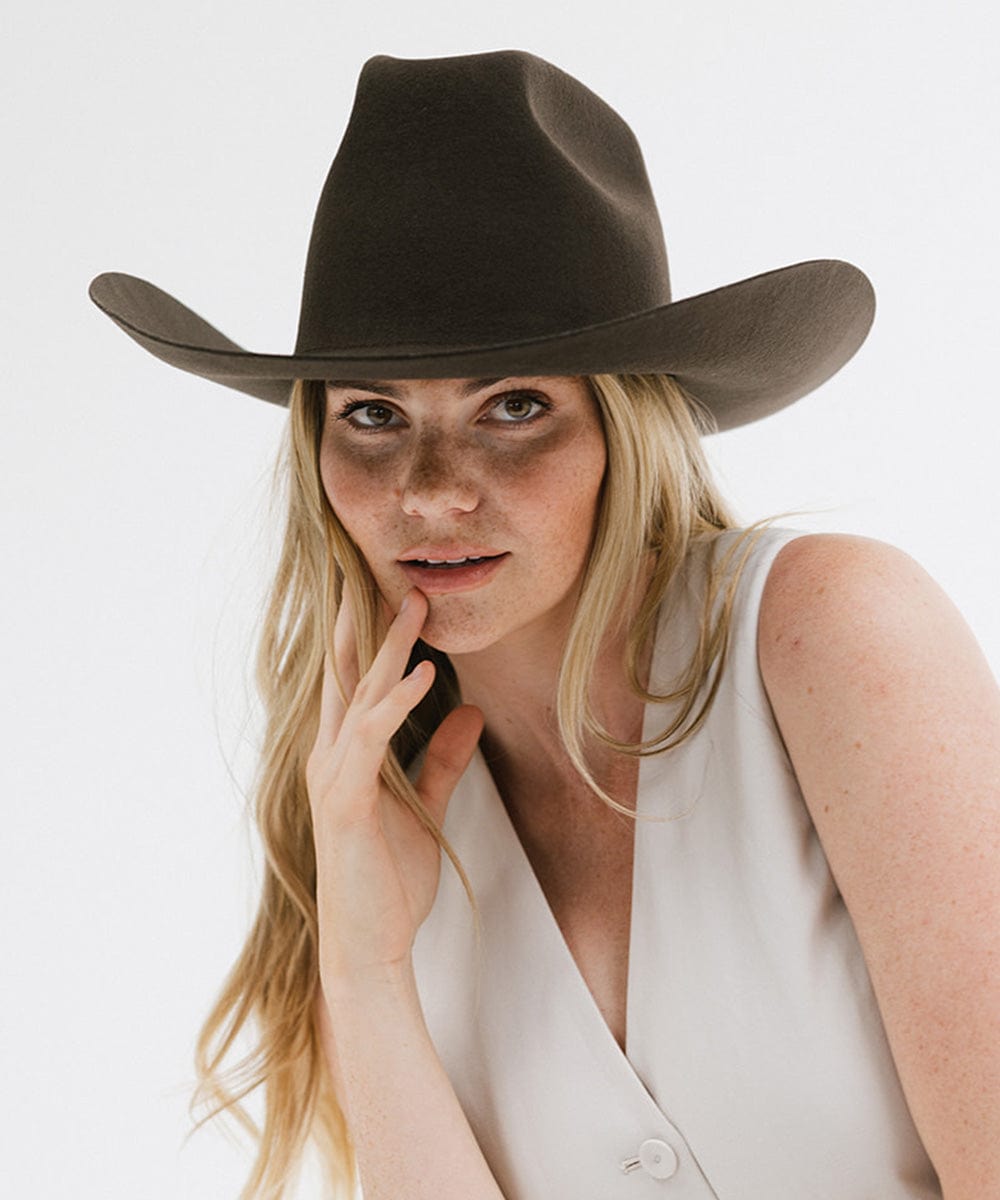 Lane Cowboy Hat worn by model, featuring a wide brim and unique brick top crown for a bold Western look.
