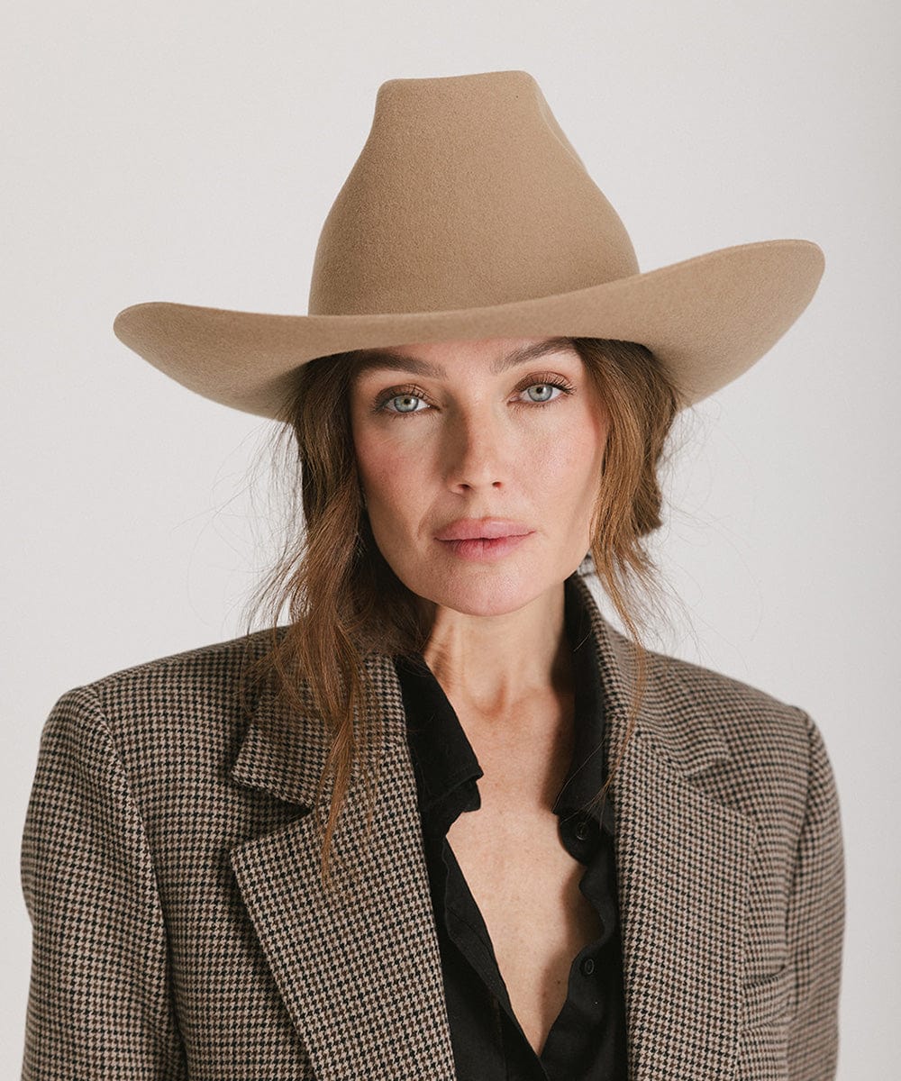 Stylish woman modeling the Lane Cowboy Hat, featuring a wide brim and unique brick top crown.