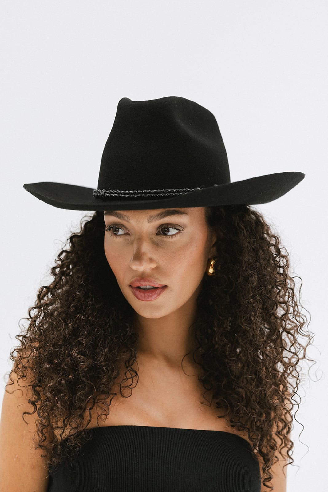 Woman wearing a stylish black Lane Cowboy Hat with a wide brim and unique crown design, exuding western chic.