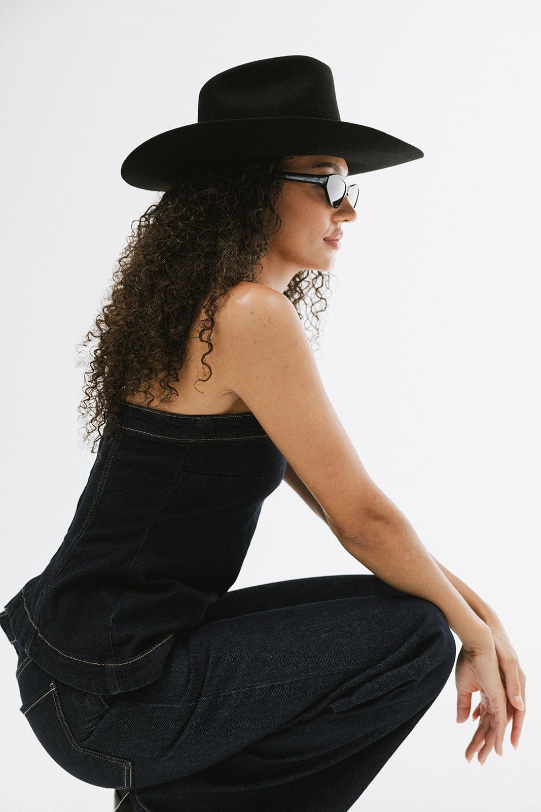 Stylish woman wearing Lane Cowboy Hat with black wide brim and sunglasses, showcasing a modern Western look.