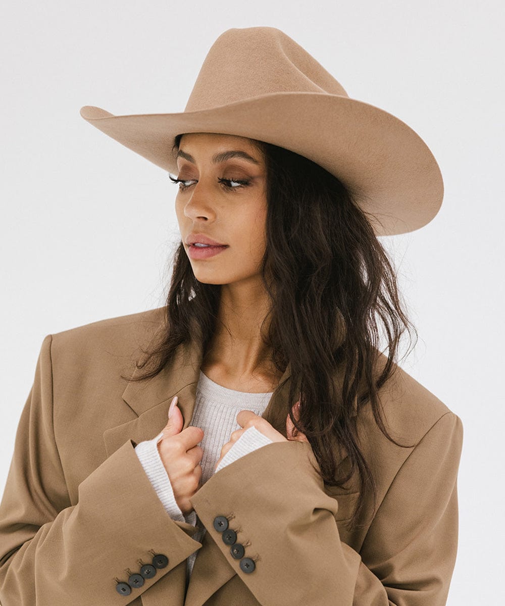 Woman wearing a Teddy Cattleman cowboy hat with a stylish oversized blazer.