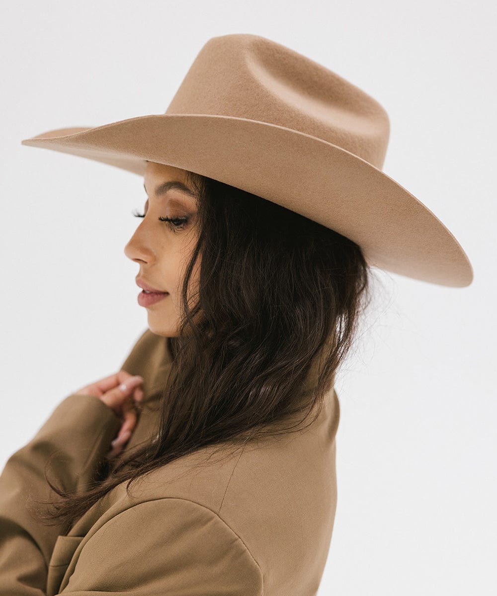 Profile view of a woman wearing a Teddy Cattleman cowboy hat, showcasing its classic western style.