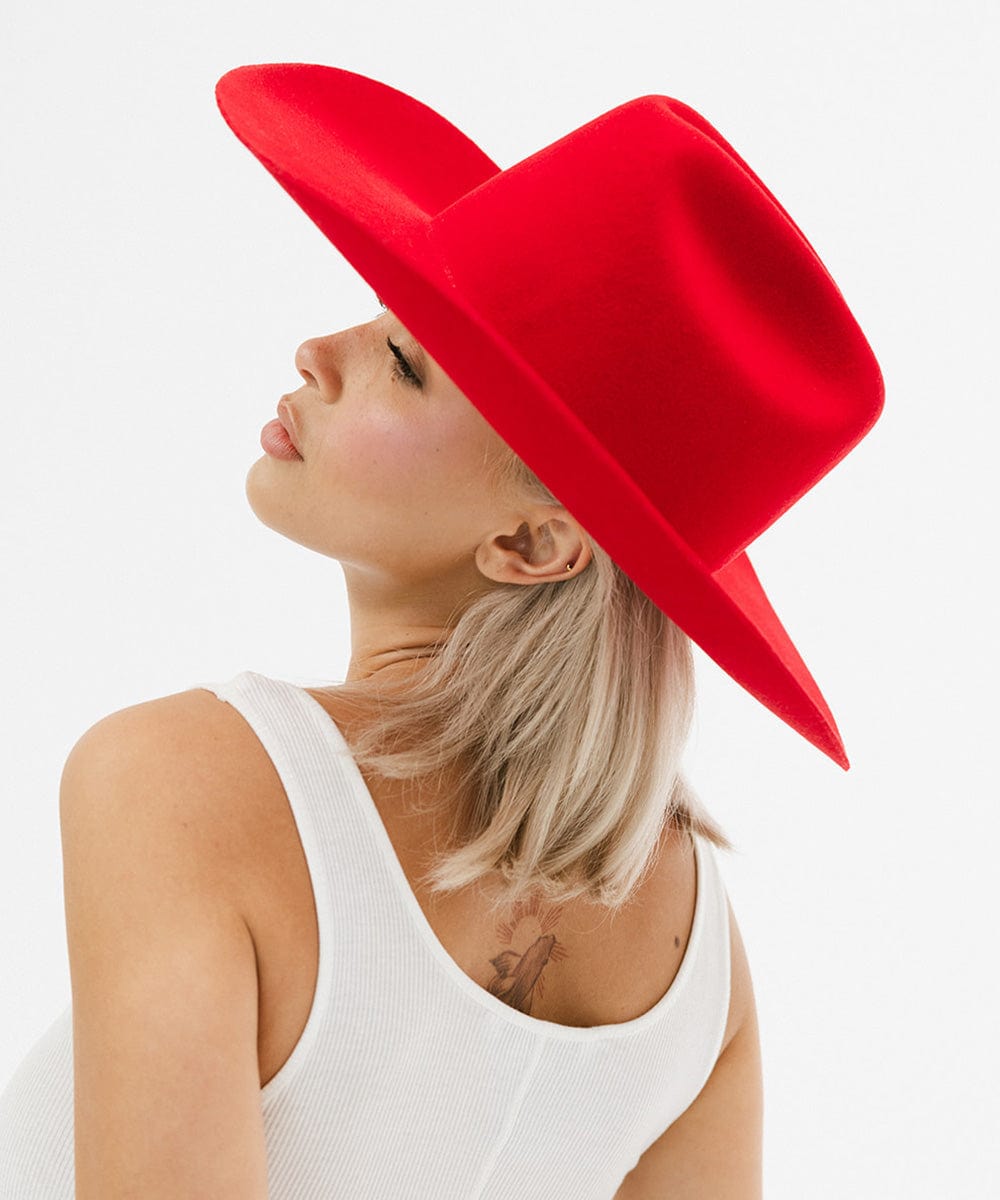 Woman in a bold red Teddy Cattleman cowboy hat, showcasing classic western style and vibrant fashion.