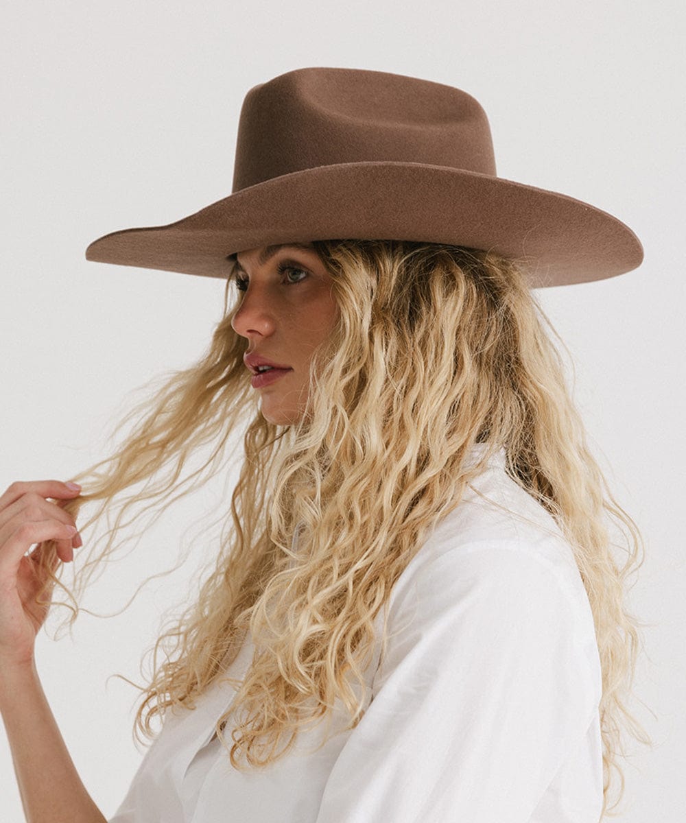 Profile of a woman wearing a Teddy Cattleman cowboy hat, showcasing its classic western style and felt texture.