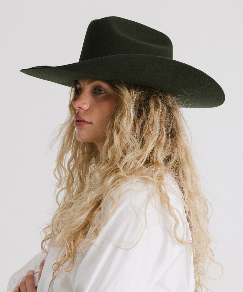 Profile view of a woman wearing a Teddy Cattleman felt cowboy hat in dark green, showcasing classic western style.