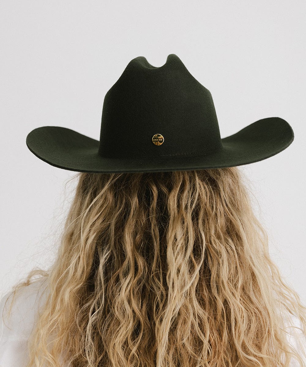 Back view of a woman with long, curly hair wearing a Teddy Cattleman Cowboy Hat in dark green.