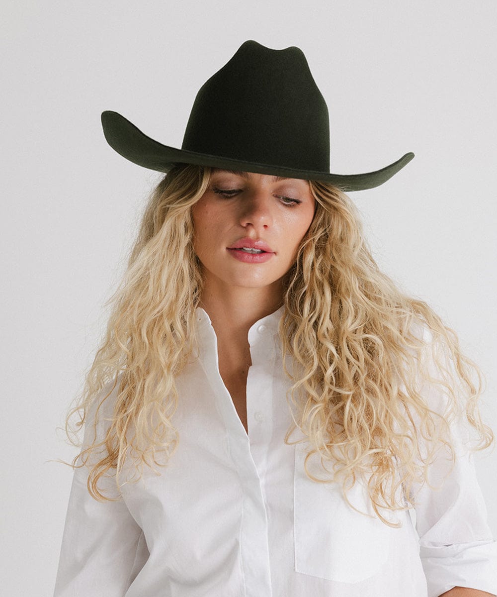 Woman wearing a Teddy Cattleman cowboy hat, showcasing classic western style with a wide brim.