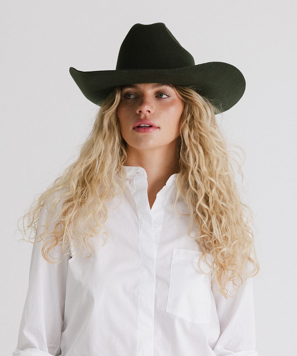 Woman wearing a black Teddy Cattleman cowboy hat, showcasing timeless Western style.