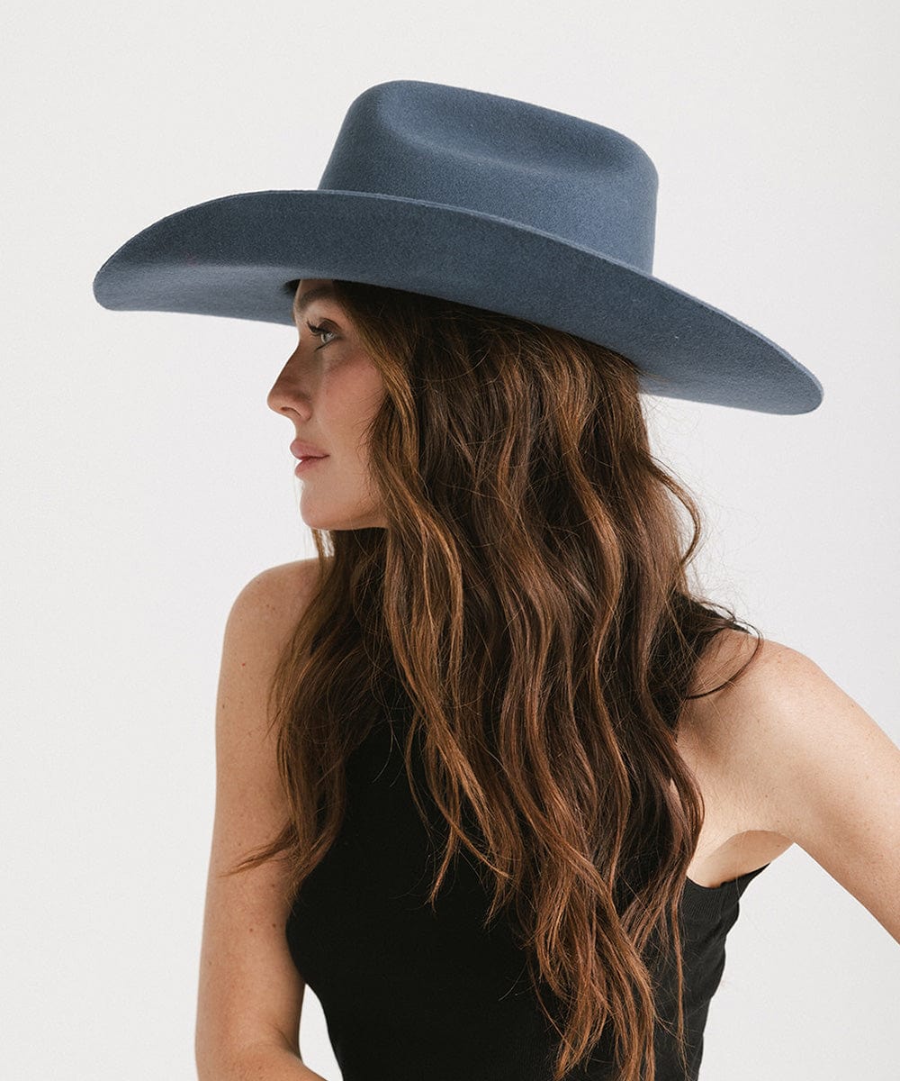 Stylish woman in profile wearing a Teddy Cattleman cowboy hat with a wide brim and a classic western crown.