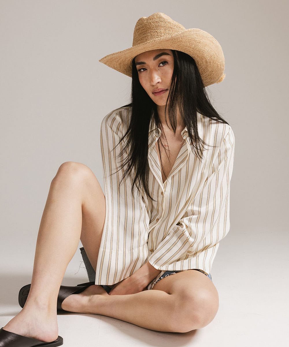 Woman wearing Ames Packable Straw Cowboy Hat with a striped shirt, showcasing a stylish Western look.