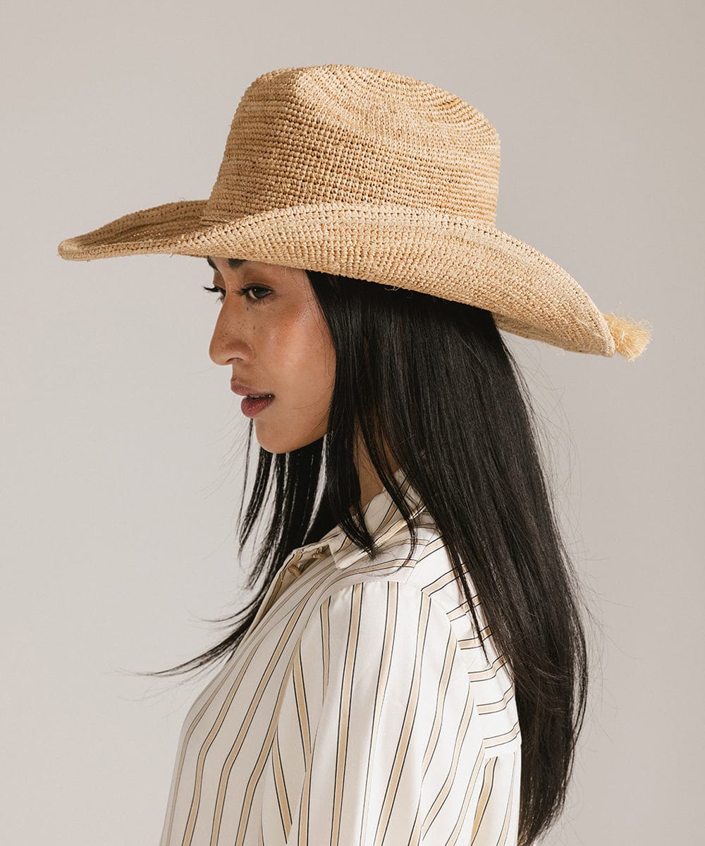 Side view of a woman wearing a lightweight crochet raffia straw cowboy hat for a stylish Western look.