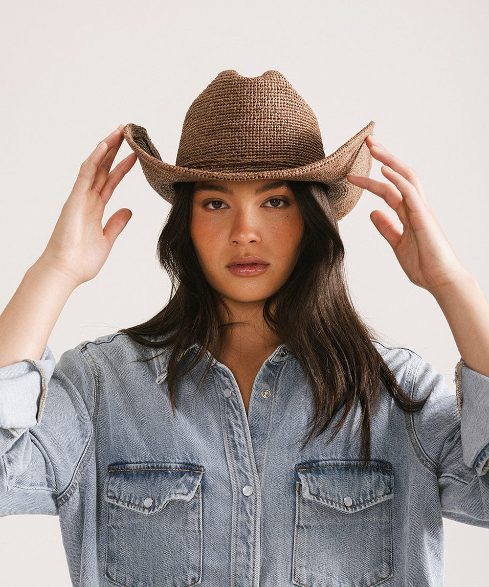 Model wearing an Ames Packable Straw Cowboy Hat, adding Western charm to her outfit.